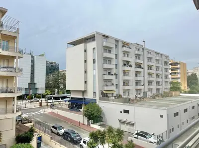 a large white building with cars parked in front of it at Mérimée in Le Cannet