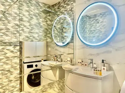 a bathroom with a washing machine and a sink at Mérimée in Le Cannet