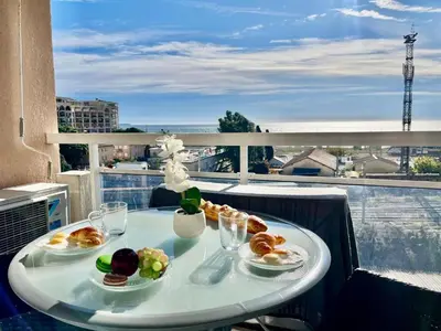 a table with plates of food on a balcony at L'Eburneen in Cannes