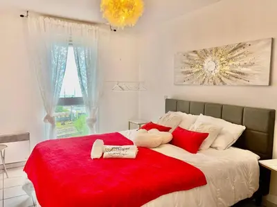 a bedroom with a large bed with red pillows at L'Eburneen in Cannes