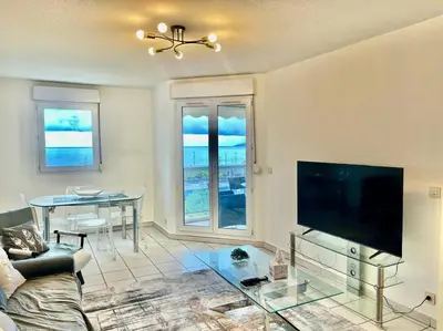 a living room with a flat screen tv and a table at L'Eburneen in Cannes