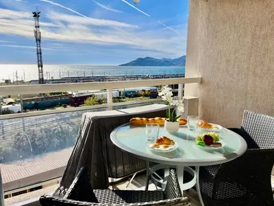 a table on a balcony with a view of the ocean at L'Eburneen in Cannes