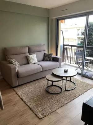 a living room with a couch and a table at Cannes Appartement neuf tout confort in Le Cannet