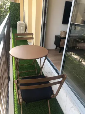 a table and chair sitting on a balcony at Cannes Appartement neuf tout confort in Le Cannet
