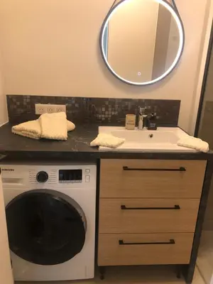 a bathroom with a washing machine and a sink at Cannes Appartement neuf tout confort in Le Cannet