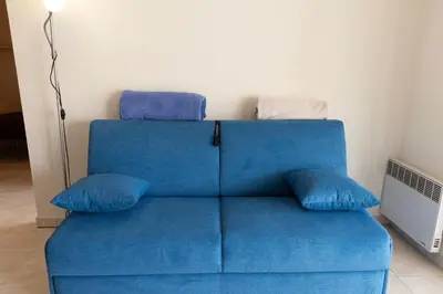 a blue couch with pillows on top of it at Charming Apartment in Cannes 10-min to beach in Cannes