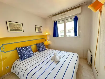 a bedroom with a bed with blue and white pillows at Charming Apartment in Cannes 10-min to beach in Cannes