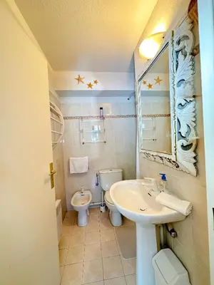 a bathroom with a sink and a toilet and a mirror at Charming Apartment in Cannes 10-min to beach in Cannes