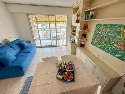 a living room with a table with plates of food on it at Charming Apartment in Cannes 10-min to beach in Cannes