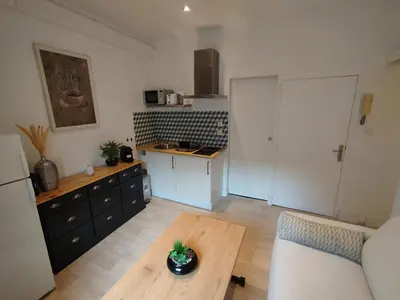 a living room with a table and a kitchen at 2 pièces Cannes centre in Cannes