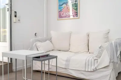 a white couch in a living room with a table at BEAU REZ DE JARDIN- Cannes Suquet - Clim- Calme - Lumineux- 15 minutes Palais des Festival in Cannes