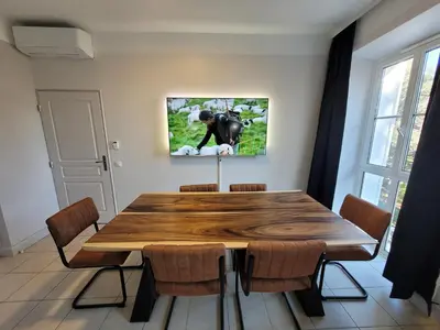 a dining room with a wooden table and chairs at Appartement 3P dans Maison Bourgeoise - 6 personnes - Vue Mer - Parking in Cannes