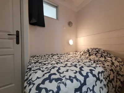 a bedroom with a bed with a black and white comforter at Appartement 3P dans Maison Bourgeoise - 6 personnes - Vue Mer - Parking in Cannes