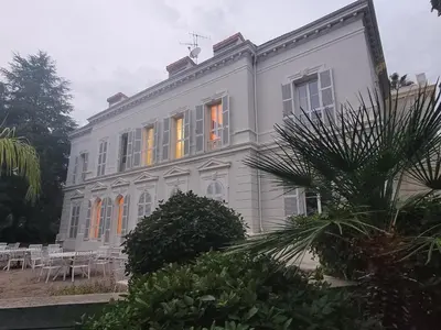 a large white house with lights in the windows at Appartement 3P dans Maison Bourgeoise - 6 personnes - Vue Mer - Parking in Cannes