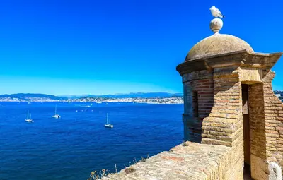 a stone wall with boats in the water at Appartement 3P dans Maison Bourgeoise - 6 personnes - Vue Mer - Parking in Cannes