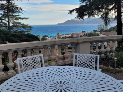 a white table and chairs on a balcony overlooking the ocean at Appartement 3P dans Maison Bourgeoise - 6 personnes - Vue Mer - Parking in Cannes