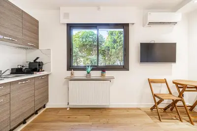 a kitchen with a window and a table and chairs at 4 BARON - Spacieux studio rénové quartier des Anglais in Cannes