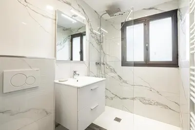 a white bathroom with a sink and a shower at 4 BARON - Spacieux studio rénové quartier des Anglais in Cannes