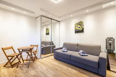 a living room with a couch and a table at 4 BARON - Spacieux studio rénové quartier des Anglais in Cannes