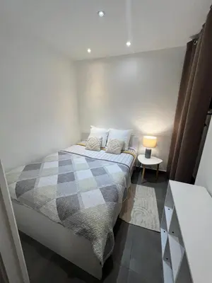 a bedroom with a bed with two pillows and a lamp at Cœur de CANNES centre ville in Cannes