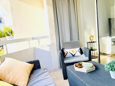 a balcony with a couch and a chair and a window at Appartement 2 pièces à Cannes in Cannes