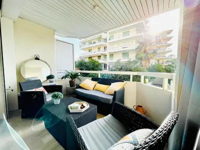 a patio with a couch and a table on a balcony at Appartement 2 pièces à Cannes in Cannes
