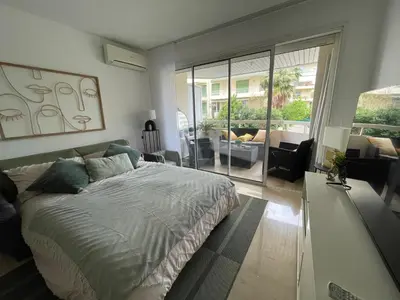 a bedroom with a bed and a living room at Appartement 2 pièces à Cannes in Cannes