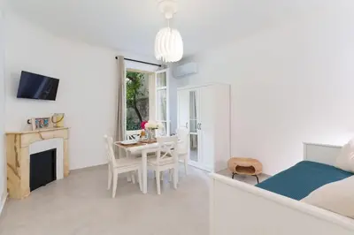 a bedroom with a bed and a dining room with a table at Le Bosquet - Quiet - Hypercentre - AC - Garden in Cannes