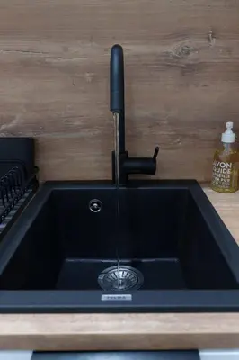 a black kitchen sink with a faucet at Le Bosquet - Quiet - Hypercentre - AC - Garden in Cannes