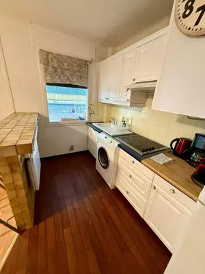 a kitchen with white cabinets and a washing machine at Studio Vidal in the city center of Cannes with AC in Cannes