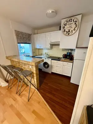 a kitchen with white cabinets and a counter with chairs at Studio Vidal in the city center of Cannes with AC in Cannes