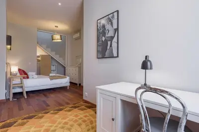 a living room with a bed in the background at Cannes La Vie - Palais, plages, clim, terrasse in Cannes