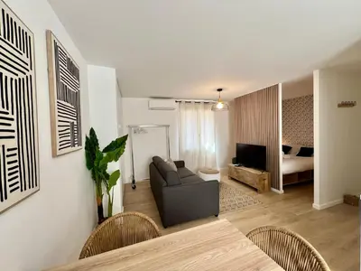 a living room with a couch and a bedroom at C003 Cosy a 200 m du Palais plein centre Cannes in Cannes