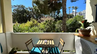 two chairs and a table on a balcony with trees at B023 Tres bel appartement proche de la mer a Cannes in Cannes
