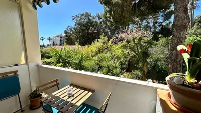 a balcony with a wooden table and chairs and plants at B023 Tres bel appartement proche de la mer a Cannes in Cannes