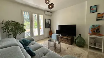 a living room with a couch and a flat screen tv at B023 Tres bel appartement proche de la mer a Cannes in Cannes