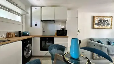 a kitchen with a table with a blue vase on it at B023 Tres bel appartement proche de la mer a Cannes in Cannes