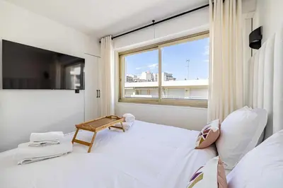 a bedroom with a white bed and a window at Harmony with private terrace - near Croisette in Cannes