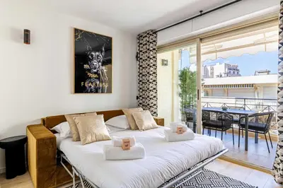 a bedroom with a large bed in a room with a balcony at Harmony with private terrace - near Croisette in Cannes