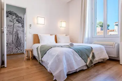 a bedroom with a large bed with white sheets at Upscale 3-room apartment 200m from the Palais in Cannes