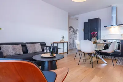 a living room with a couch and a table and chairs at Upscale 3-room apartment 200m from the Palais in Cannes