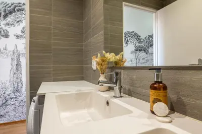 a bathroom sink with a bottle of alcohol on it at Upscale 3-room apartment 200m from the Palais in Cannes