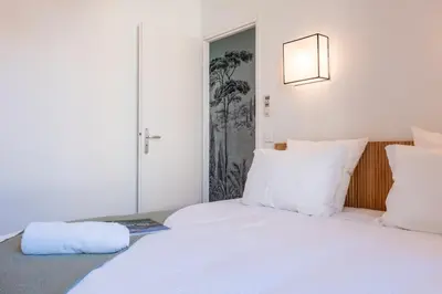 a bedroom with a bed with white sheets and pillows at Upscale 3-room apartment 200m from the Palais in Cannes
