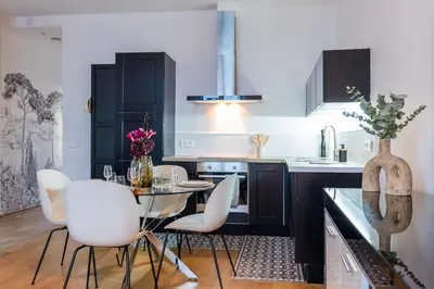 a kitchen with a dining table and white chairs at Upscale 3-room apartment 200m from the Palais in Cannes