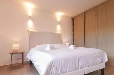 a bedroom with a white bed with two white towels at Magnifique vue mer, grande terrasse et piscine in Cannes