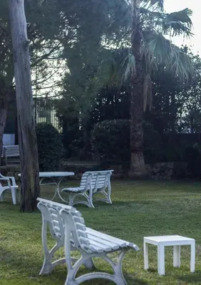 a group of white benches sitting in a park at Magnifique vue mer, grande terrasse et piscine in Cannes