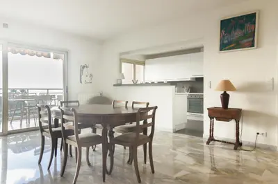 a kitchen and dining room with a table and chairs at Magnifique vue mer, grande terrasse et piscine in Cannes