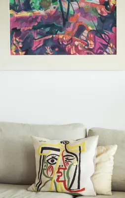 a pillow sitting on top of a couch with a painting at Magnifique vue mer, grande terrasse et piscine in Cannes