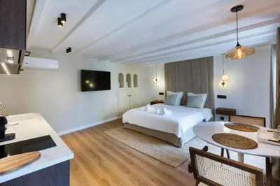 a bedroom with a white bed and a kitchen at Luxury suite Forville - Cannes center in Cannes