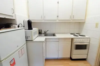 a small kitchen with white cabinets and a sink at Rocamare in Cannes